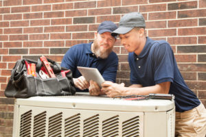 Air Conditioner Repairmen Work On Home Unit. Digital Tablet.